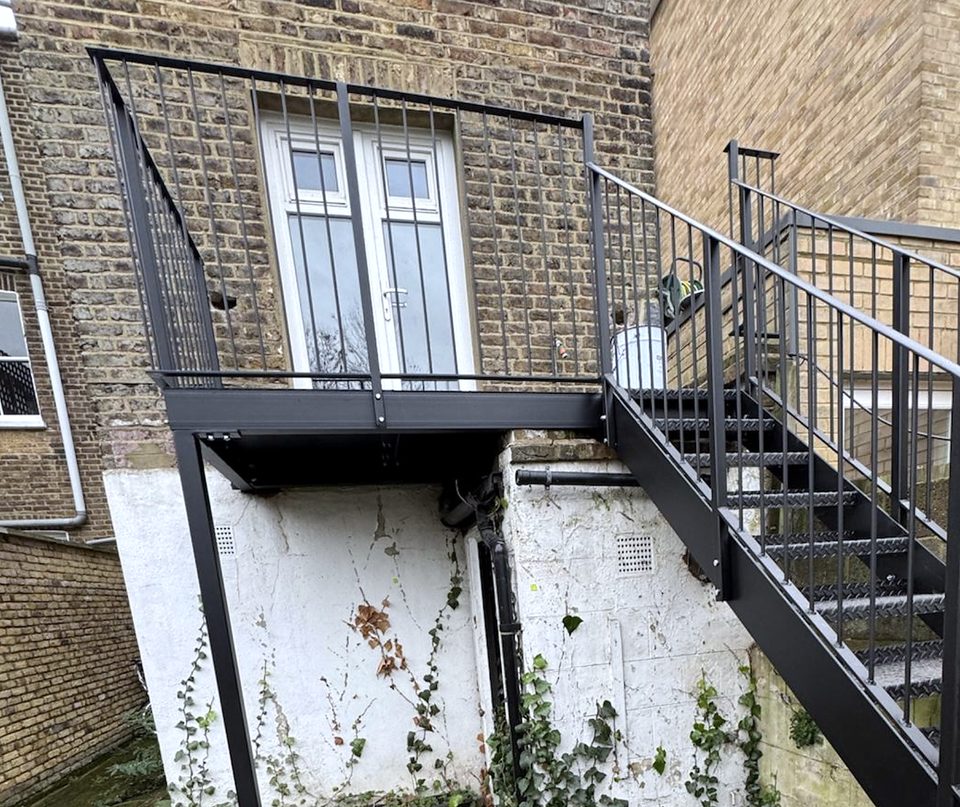 Black steel balcony on a single post with a stair to the garden, the type that needs balcony planning permission in Bromley and elsewhere