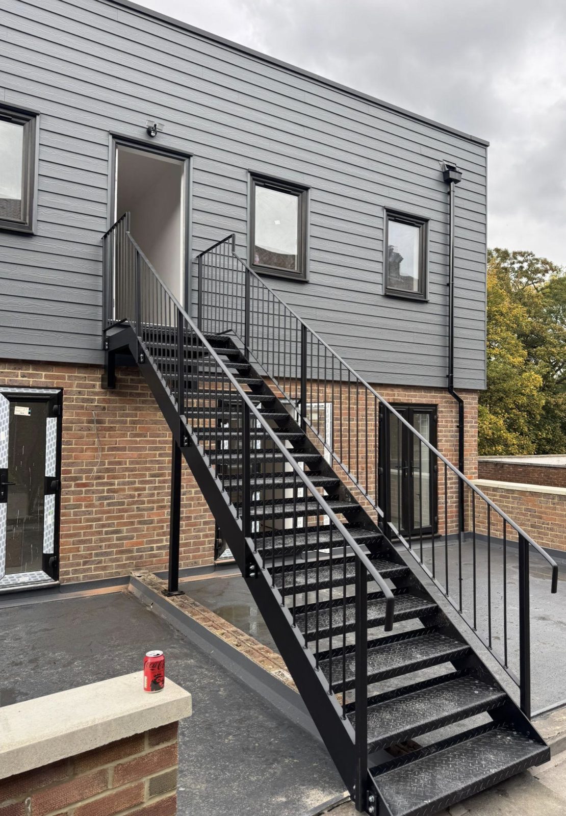Black external staircase on a clad building