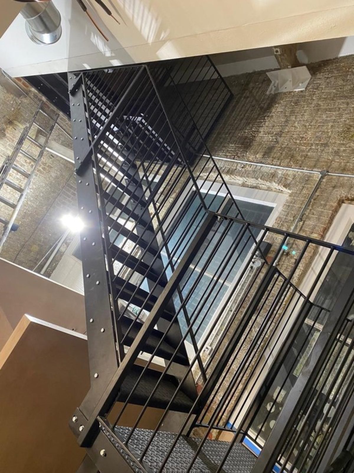 Black steel staircase beside a glazed building
