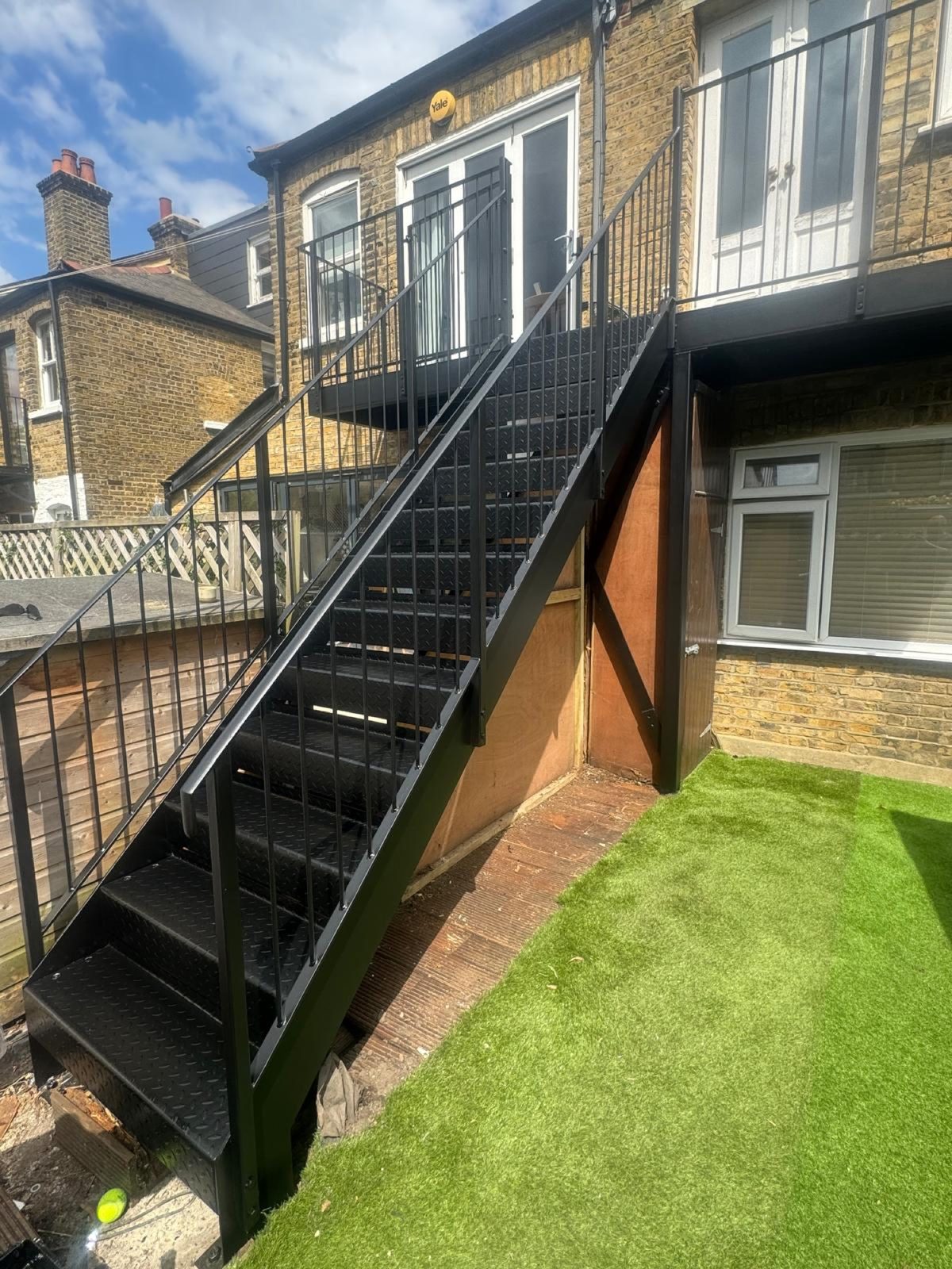 Black steel staircase to a first-floor flat