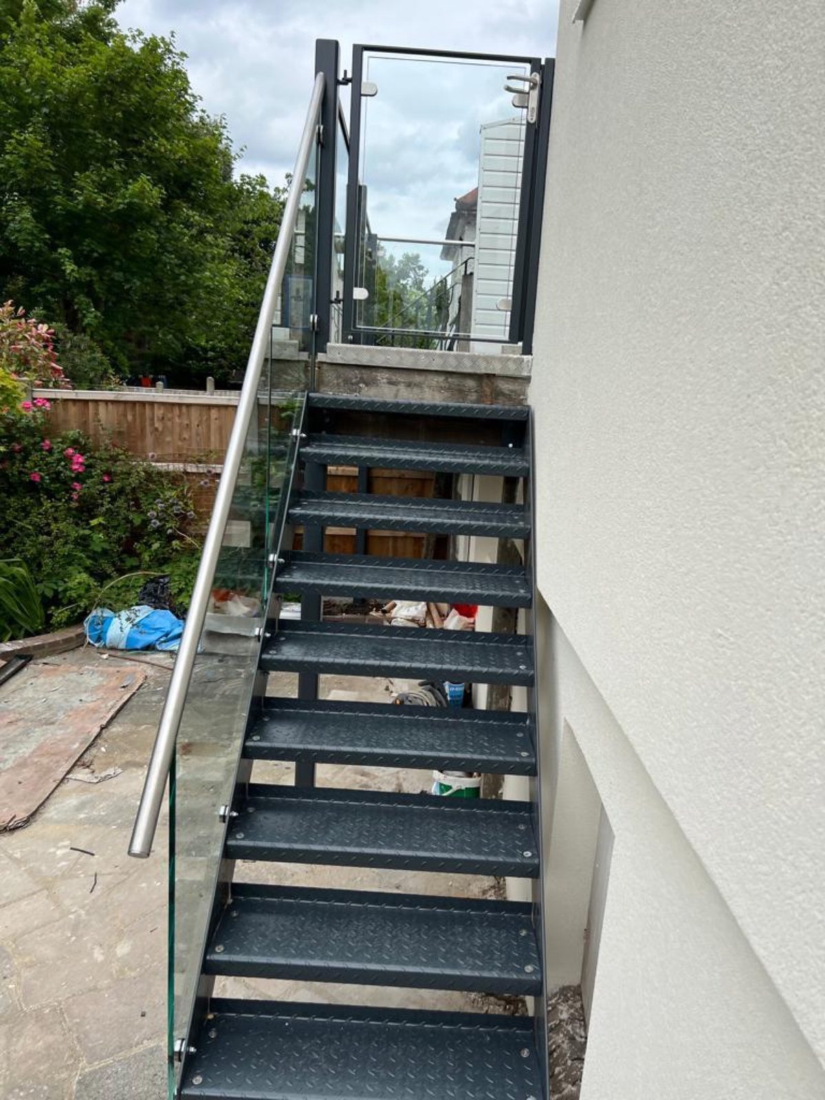Grey external steel staircase on a rendered house