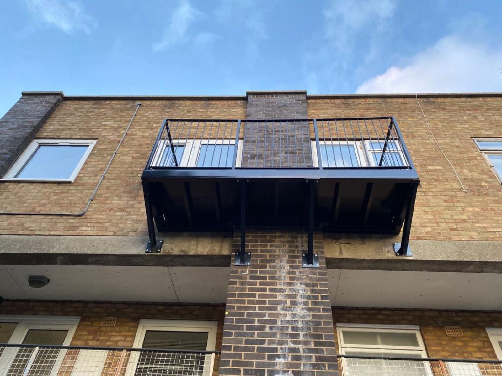 Black steel balcony on a brick block