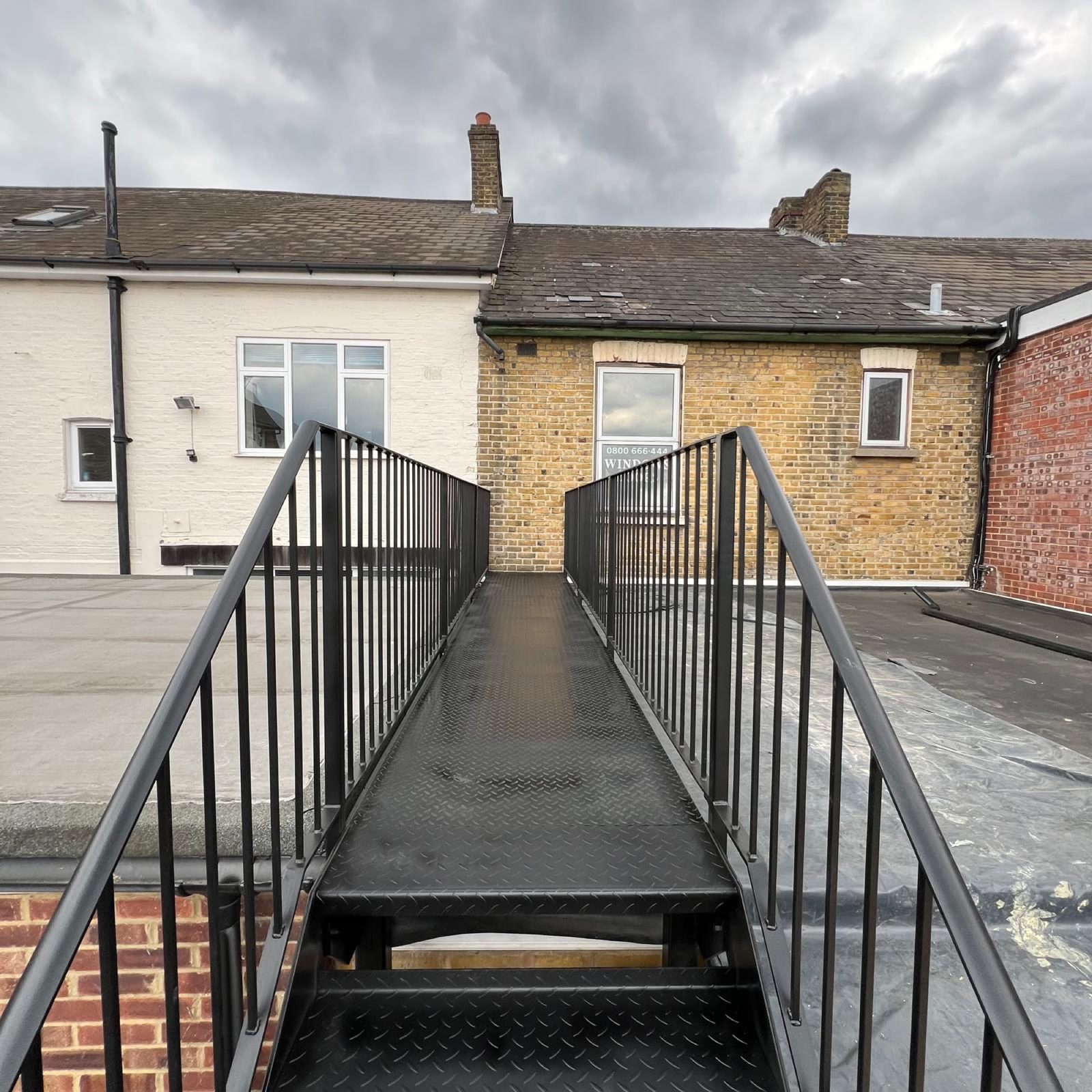 Steel walkway with railings to a roof terrace